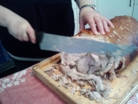 Silvana cutting the pork for Bianca's birthday party.