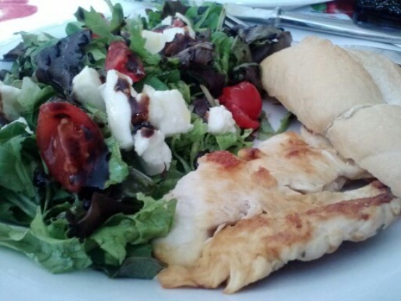 Pollo grigliato con pane e insalata mista. Grilled chicken with bread and tossed salad (the salad has mozzarella in it).